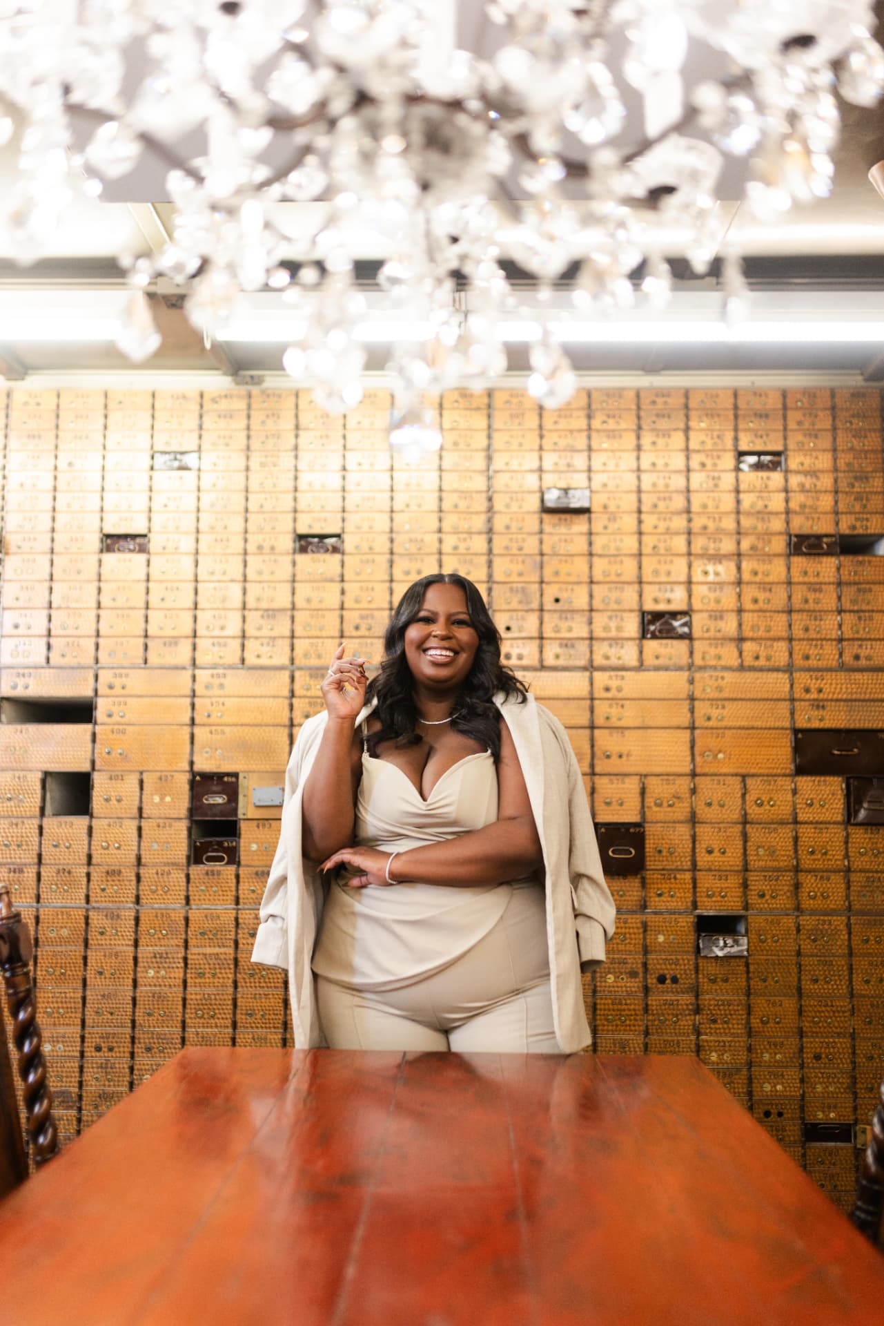 Amber M. Lewis, founder of Social 'N The City, standing before a wall of vintage mailboxes